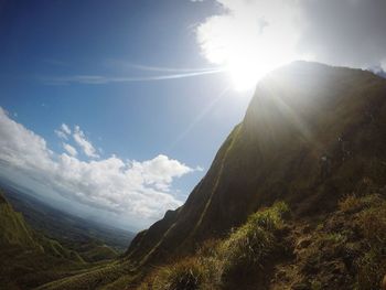 Scenic view of mountains against sky in sunny day