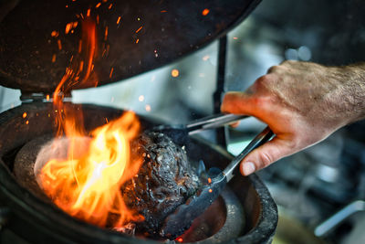 Midsection of person preparing burning fire