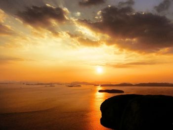 Scenic view of sea against dramatic sky during sunset