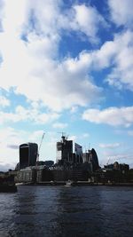 Buildings in city against cloudy sky