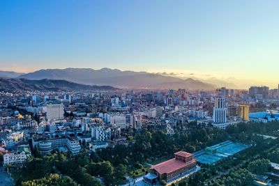 High angle view of city buildings against sky during sunset