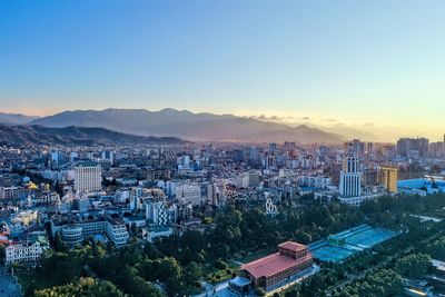 High angle view of city buildings against sky during sunset