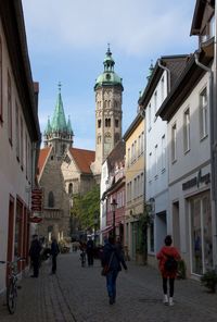 People walking on street amidst buildings in city