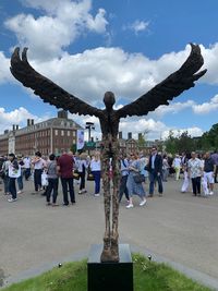 Group of people on sculpture against sky