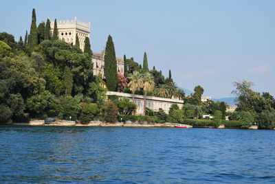 Scenic view of river by building against sky