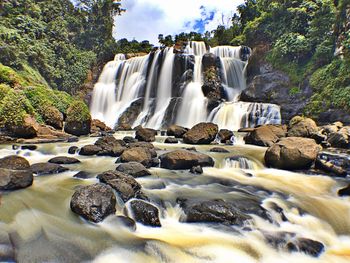 Scenic view of waterfall against sky