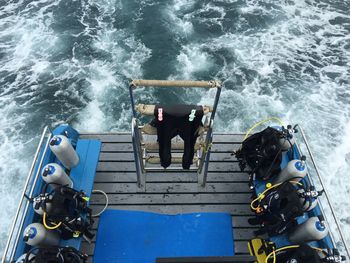 High angle view of boat in sea waves and scuba gears