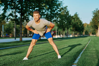 Full length of man exercising on field