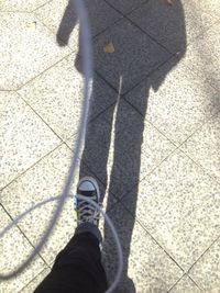 Low section of person standing on tiled floor