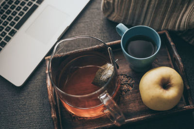 Still life of a natural breakfast at home beside a laptop on the sofa. tea, coffee on a wooden tray 