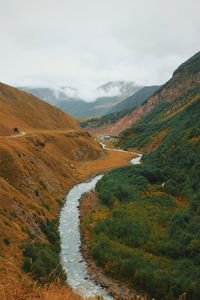 Scenic view of river amidst mountains against sky