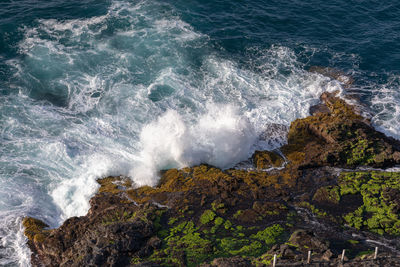 High angle view of waves breaking on rocks