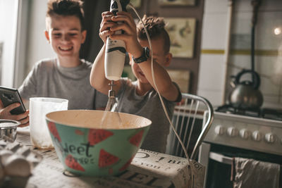 Close-up of boy holding drink at home