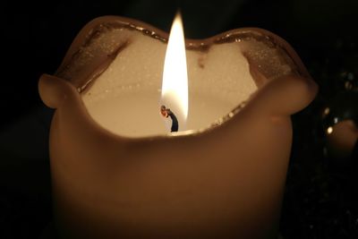 Close-up of lit candle against black background