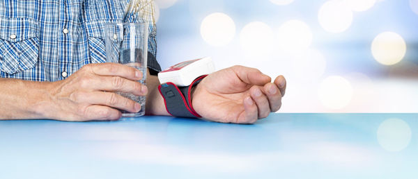 Close-up of man holding hands on table