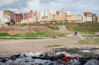 People by buildings in city against sky