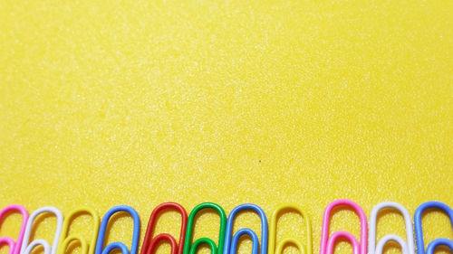 Close-up of multi colored pencils against yellow background