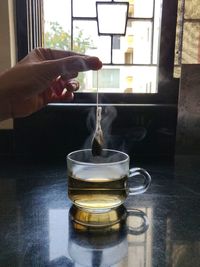 Person pouring tea in glass