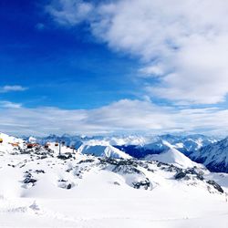 Scenic view of snowcapped mountains against blue sky