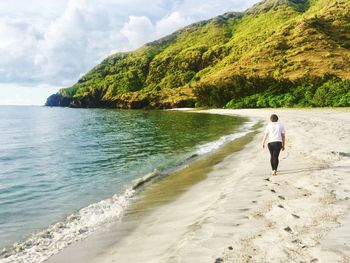 Rear view of man walking on beach