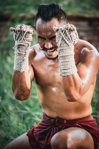 Midsection of shirtless man standing outdoors