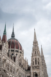 Low angle view of hungarian parliament building against cloudy sky