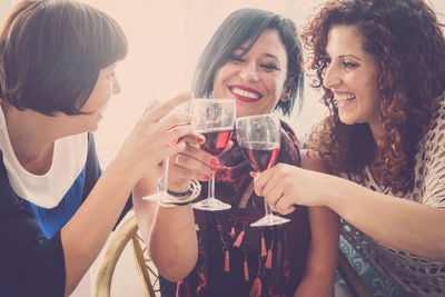 Female friends toasting wineglasses at home