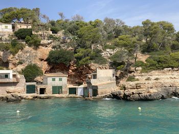 Buildings by sea against sky