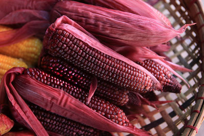 Close-up of red corns in basket for sale in market