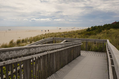 Footpath by sea against sky