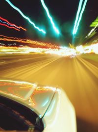 Light trails on road against sky at night