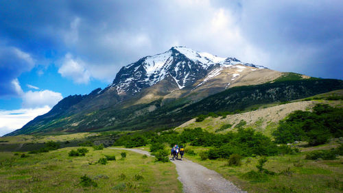 People with back packs walking on country road