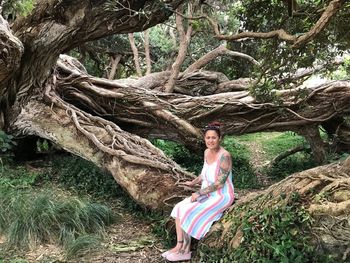 Portrait of woman with tree trunk