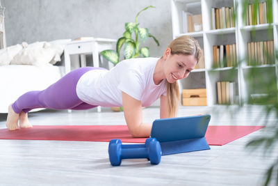 Full length of woman exercising at home