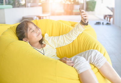Full length of girl using mobile phone at home