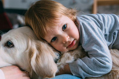 Cute baby and his labrador retriever at home on the bed.