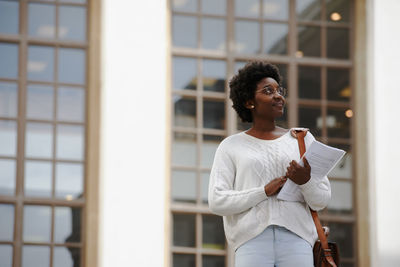 Full length of teenage girl standing against window