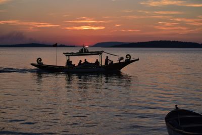 Boat on sea against sky during sunset