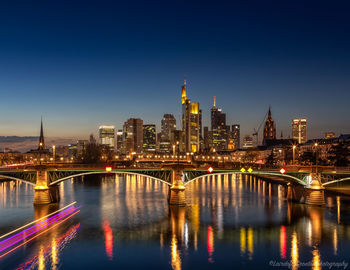 Illuminated bridge over the river main at night with a view of mainhattan