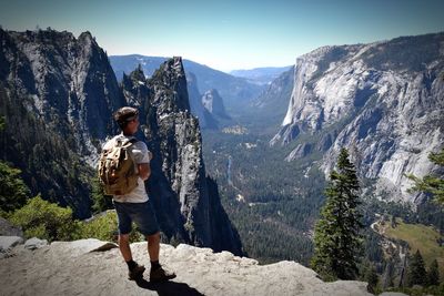 Man standing on rock looking at mountains