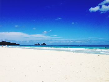 Scenic view of beach against blue sky