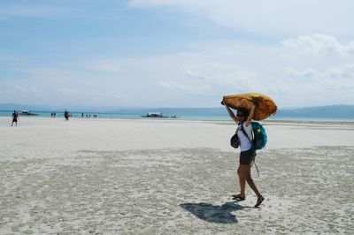 Full length of woman standing on beach against clear sky