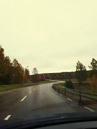 Road seen through car windshield against sky