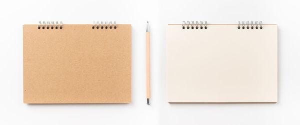 Directly above shot of spiral notebooks against white background