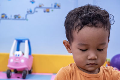 Close-up of thoughtful baby boy looking down in preschool