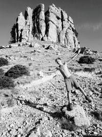 Full length portrait of boy with arms outstretched standing at monumento naturale perdae liana