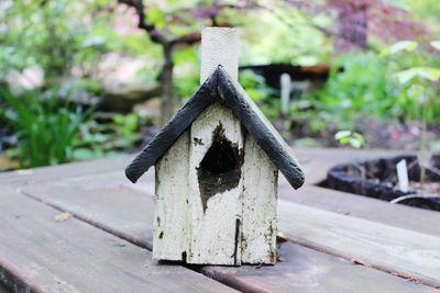 Close-up of birdhouse on wooden bench