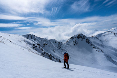 Full length of person skiing on snowcapped mountain against sky