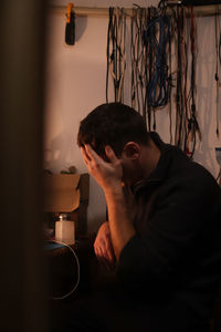 Tired young man, engineer soldering black laptop. electronic renovation in repair service. worker 