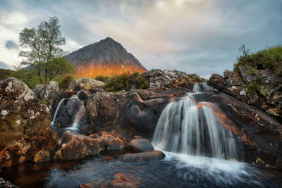 Scenic view of waterfall against sky